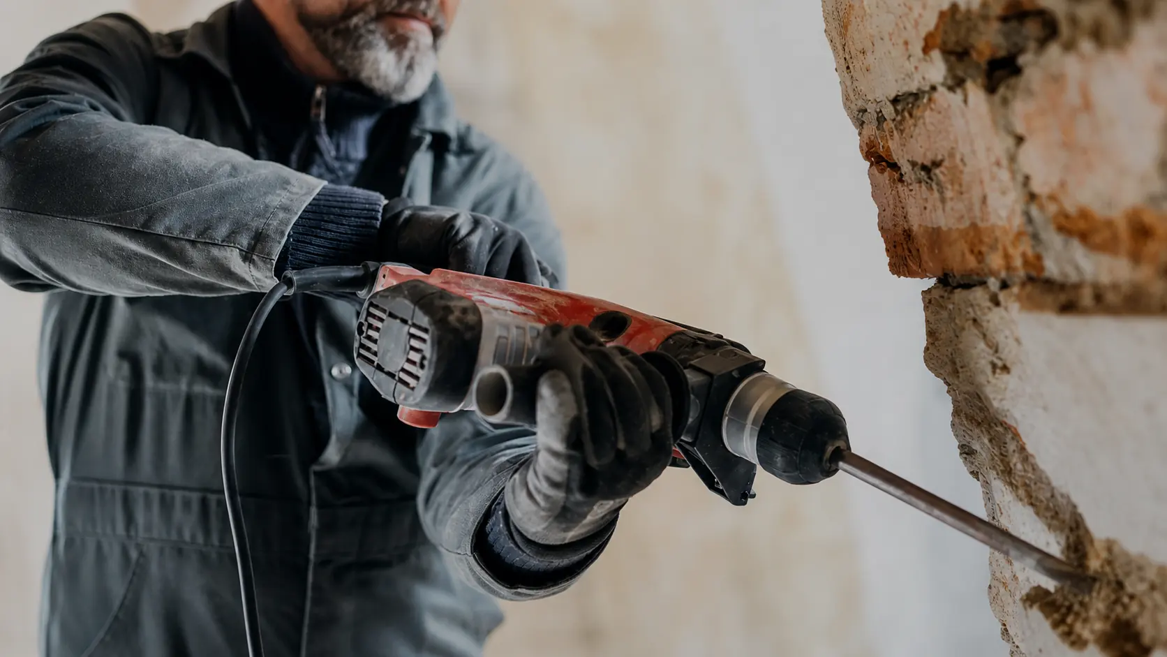 Handwerker bohrt in eine massive Wand