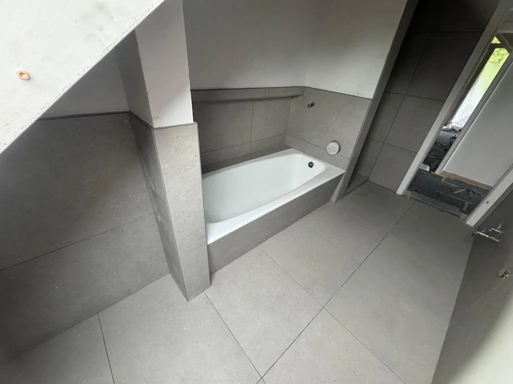 Saniertes Badezimmer mit Badewanne und großformatigen Fliesen